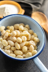 Uncooked potato gnocchi in colander. Tasty italian food.
