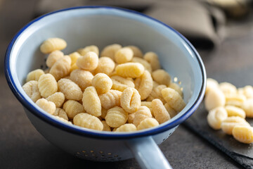 Uncooked potato gnocchi in colander. Tasty italian food.