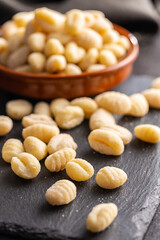 Uncooked potato gnocchi on cutting board. Tasty italian food.