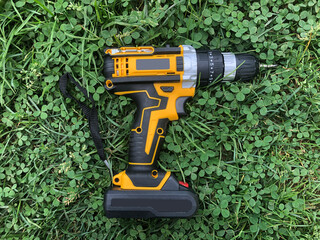 wireless rechargeable yellow and black screwdriver on green grass