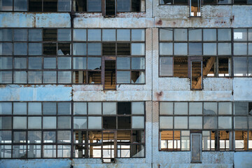 Broken glass facade old, industrial, abandoned factory building.