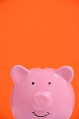 Pink piggy bank on an orange background.