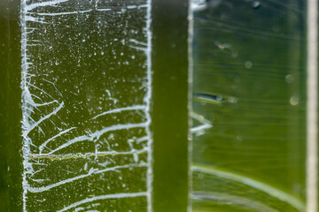 Strip of tape adhesive on a glass surface after being pulled. 