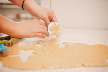 Woman hands form molds cutters ginger dough and makes delicious christmas ginger cookies. Cooking and decorating christmas dessert.