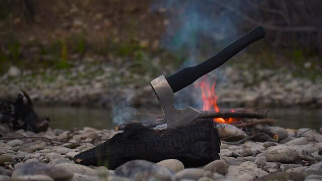 Viking ax. An ax driven into a piece of wood. Ax in the water. An ax by the fire