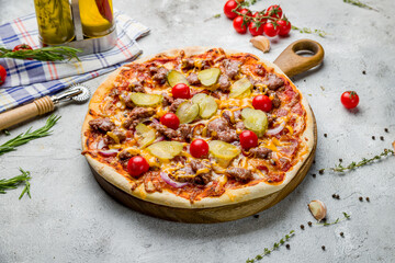 Italian meat pizza with cucumbers and tomatoes on grey table
