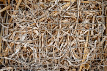 paille dans un hotel à insecte derrière une grille