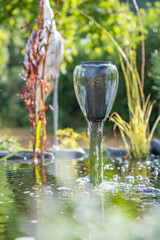 petite fontaine d'eau sur un étang artificielle avec de l'eau qui coule doucement