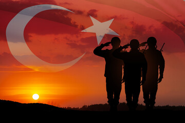 Silhouettes of soldiers on a background of Turkey flag and the sunset or the sunrise. Concept of crisis of war and conflicts between nations. Greeting card for Turkish Armed Forces Day, Victory Day.