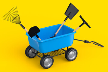 Garden wheelbarrow with garden tools like shovel, rake and fork on yellow.