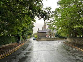 Heavy rain, with old trees, and stone cottages on, Little Horton Green, Bradford, UK 