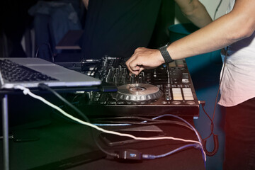 Dj que maneja los controles de la mezcladora en el entorno de la fiesta