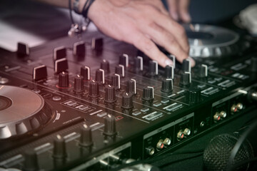 Manos de Dj moviendo los controles de la mesa de mezclas
