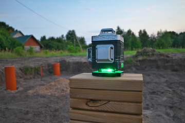 laser building level with green beams at the construction site. Selective focus.