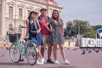 Portrait of young Hispanic friends with bicycles in the central park in  El Salvador.