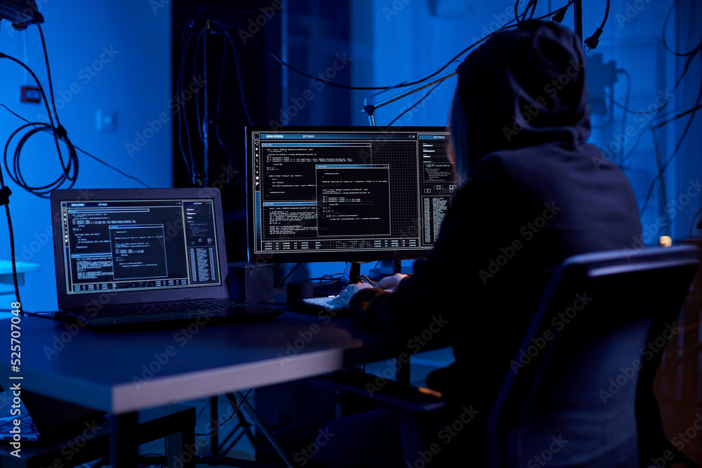 Poster cybercrime, hacking and technology concept - female hacker in dark room writing code or using comput