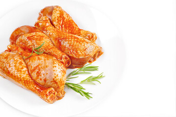 Baner.Cooking chicken drumsticks.Raw chicken legs in a marinade with rosemary on a background.Top view, copy space.Isolated.Marinated chicken dramstick with spices for cooking.