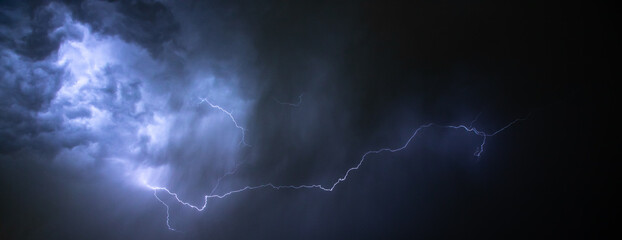 A dark cloudy sky with thunder lightning bolt strike