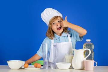 Excited funny chef cook. Child chef isolated on blue. Funny little kid chef cook wearing uniform cook cap and apron cooked food in the kitchen.