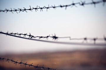 a barbed wire fence at sunset