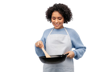 cooking food, culinary and people concept - happy smiling woman in apron with frying pan over white...