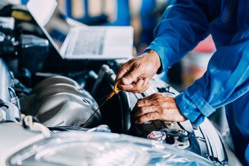 Automotive mechanic repairman using tablet and checking engine in the engine room, check the mileage of the car, oil change, auto maintenance service concept