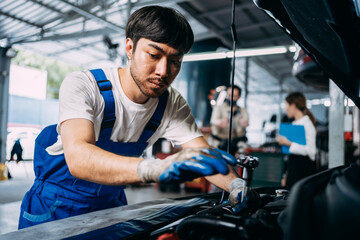 Fototapeta na wymiar Auto mechanic repairman using a socket wrench working engine repair in the garage, change spare part, check the mileage of the car, checking and maintenance service concept.