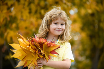 Naklejka premium Happy child, playing in the autumn park on the nature, walk outdoors.