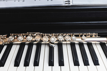 Close up of transverse flute on the keys of a piano © padnob