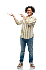 people and fashion concept - happy smiling man in glasses holding and showing something imaginary on his hand over white background