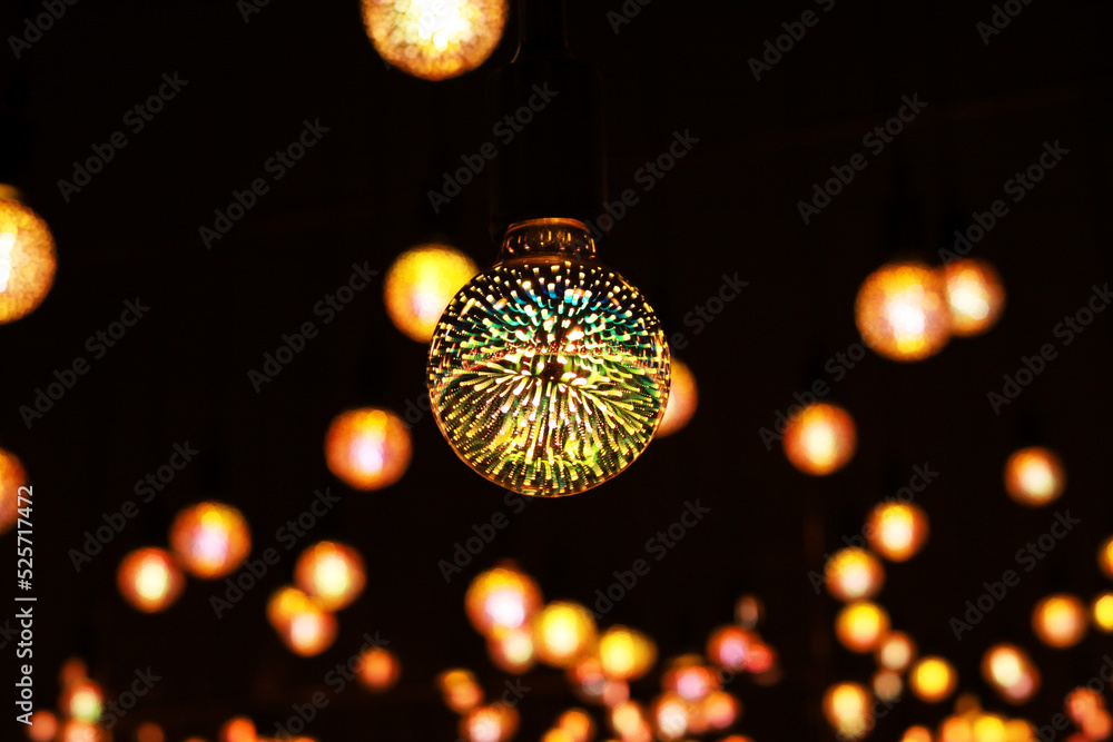 Poster light bulb with colored lights inside glows in the dark. glowing patterned colored light bulb in the