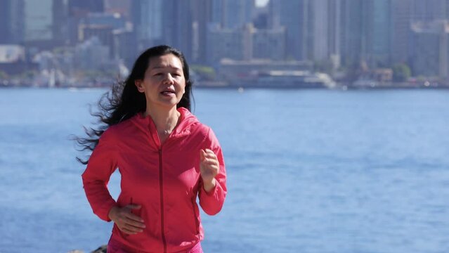 Asian woman going for her morning workout in San Diego California. San Diego skyline can be seen in the background.