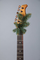 Guitar with fir tree branch on grey background. Christmas music
