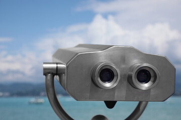 Metal tower viewer installed near sea, closeup. Mounted binoculars