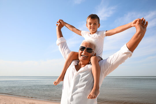 Cute Little Boy With Grandfather Spending Time Together On Sea Beach