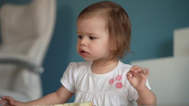 One girl small caucasian toddler child eat bread at home copy space