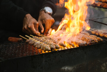 homem assando espetinho de carne