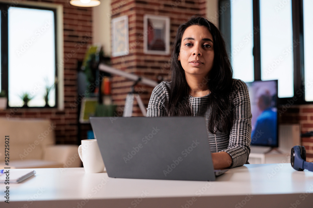 Poster portrait of indian person working from home on laptop at desk, browsing internet and sending email w
