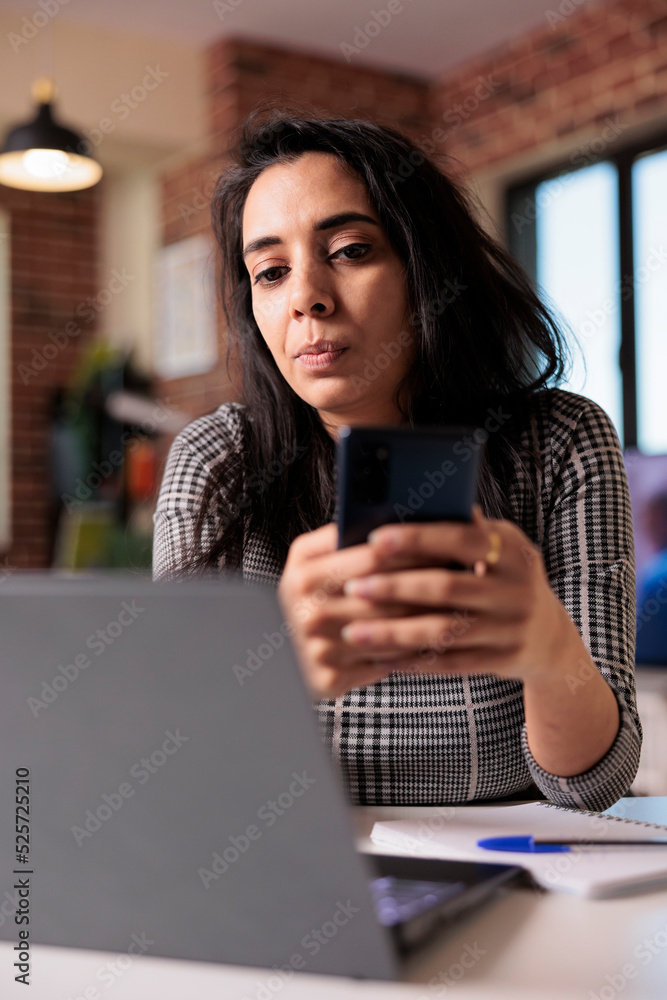 Poster student employee browsing internet on smartphone, using social media app to text messages on work br