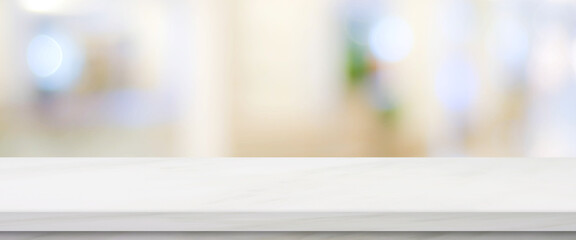 Empty white table top, counter, desk over blur perspective store with bokeh light background, White...