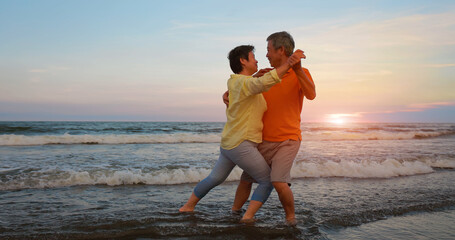 elderly couple dance on beach