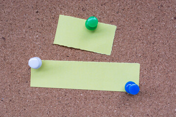 Yellow stick note and pinned to a cork notice board. Copy space.