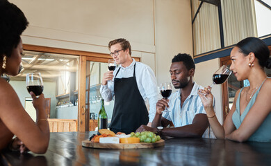 Hospitality, luxury and wine tasting at a restaurant with a professional sommelier teaching how to enjoy red wine. Diverse group having fun, celebrating their friendship with getaway and fine dining