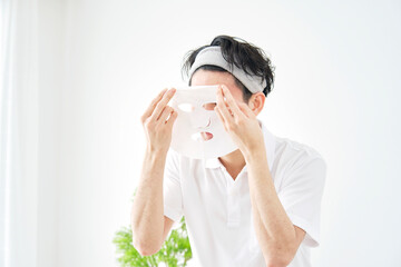 自宅でフェイスマスクをする男性