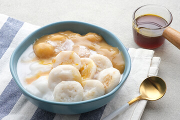 Serabi Bubur Sumsum with Candil Ubi. Indonesian traditional porridge. Served with palm sugar sauce. Sweet and savory. Popular food during ramadhan.
