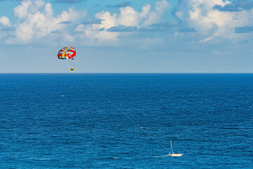 Parasailing towed behind a boat in the Caribbean sea, tropical Ocean, Vacation Concept, Cancun, Mexico