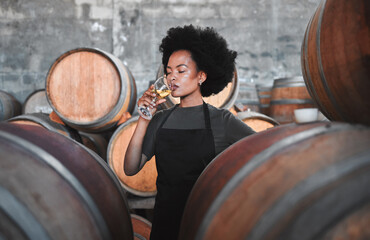 Black winemaker smelling white wine in vineyard cellar, expert analysis by professional, proud...