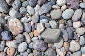 Large stones of different shapes on the riverbank close-up. there are a lot of small stones nearby.