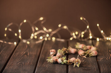 Hazelnuts on a wooden table against a dark background with bokeh.