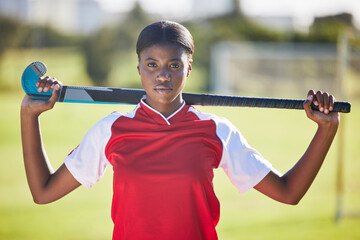 Hockey player or coach holding stick ready for a competition or match on the sports ground or field. Portrait of a serious, fit and active black woman athlete at fitness training, exercise or workout - Powered by Adobe